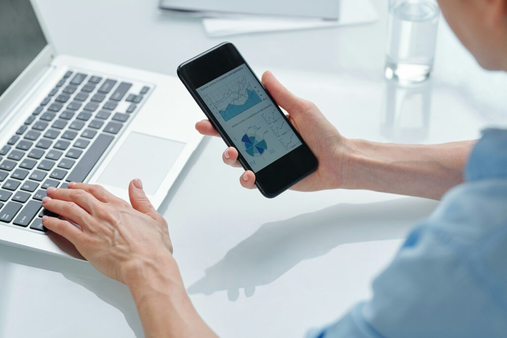 Hands of young contemporary broker analyzing financial graphs and diagrams